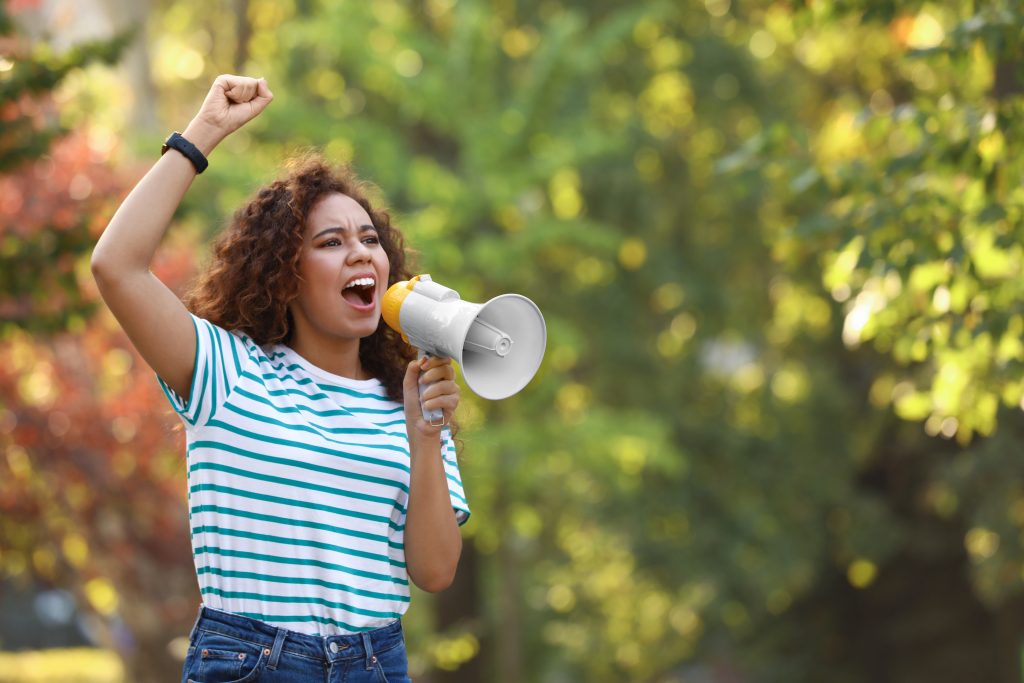 a young woman shouting into a megaphone happily